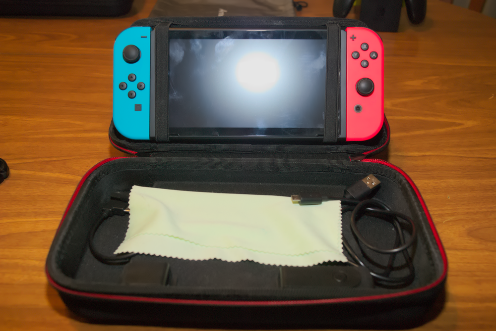 Charging case opened, with Switch strapped into the top